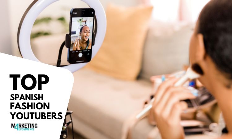 Persona maquillándose frente a un espejo de anillo con un móvil grabando; ambiente acogedor. Texto: "TOP SPANISH FASHION YOUTUBERS - MARKETING 4 ECOMMERCE".