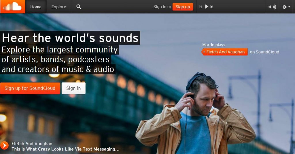 Hombre escuchando música con auriculares. Texto: "Hear the world's sounds. Explore the largest community of artists, bands, podcasters and creators of music & audio." Botones: "Sign up for SoundCloud" y "Sign in". Ambiente urbano con puente al fondo.
