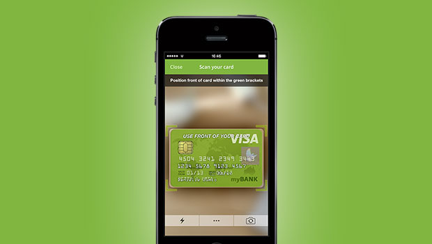 Un smartphone escanea una tarjeta de crédito Visa, resaltada en la pantalla. Fondo verde, mensaje: "USE FRONT OF YOUR CARD" y datos del banco. Marketing digital móvil.