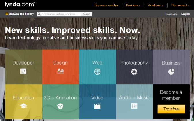 Letrero de lynda.com sobre fondo de madera. Texto: "New skills. Improved skills. Now." Botones de cursos: Desarrollo, Diseño, Web, Fotografía, Negocios. "Become a member". "Try it free".