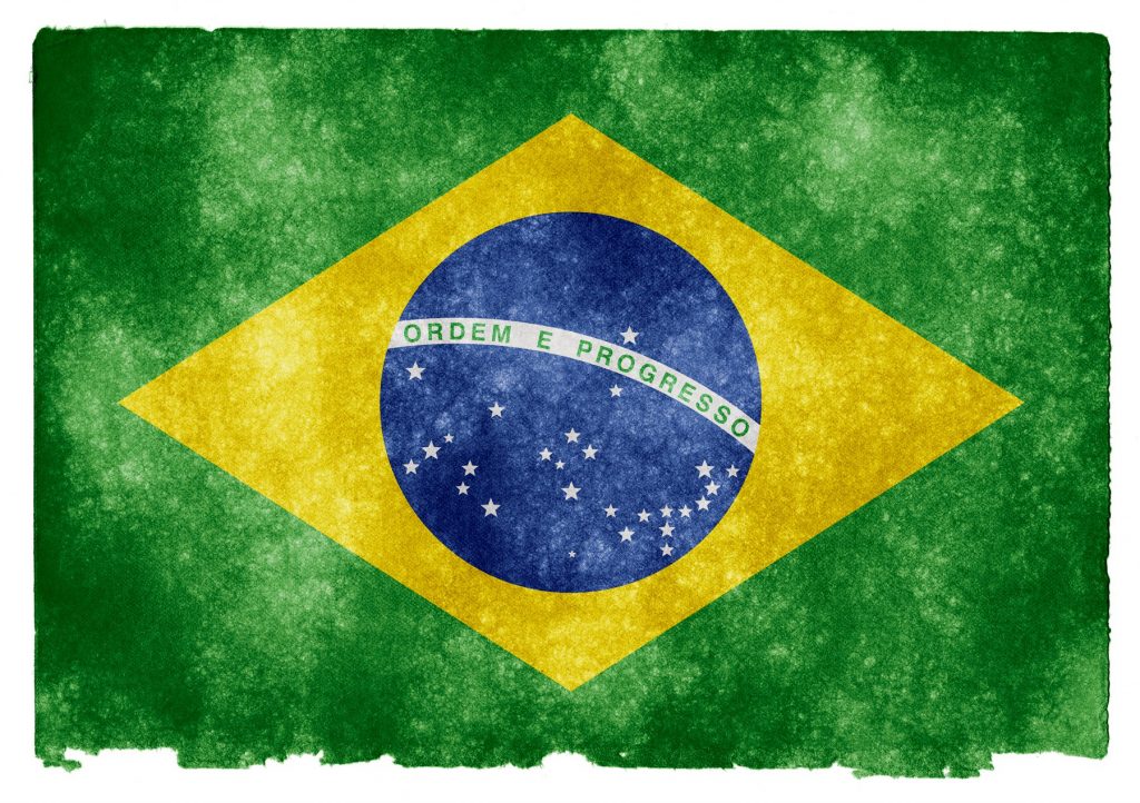 Bandera de Brasil ondea; diseño verde con rombo amarillo y círculo azul, inscripciones "Ordem e Progresso", ideal para marketing internacional.