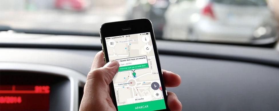 Teléfono muestra app de navegación en un coche aparcado, destacando mapa y opción "APARCAR". Ideal para marketing de movilidad y tecnología.
