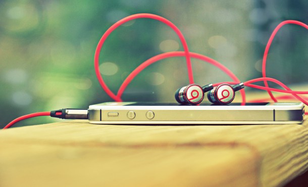 Auriculares conectados a un cable USB, flotan sobre un fondo blanco. Diseño moderno ideal para marketing digital y tecnología de sonido.