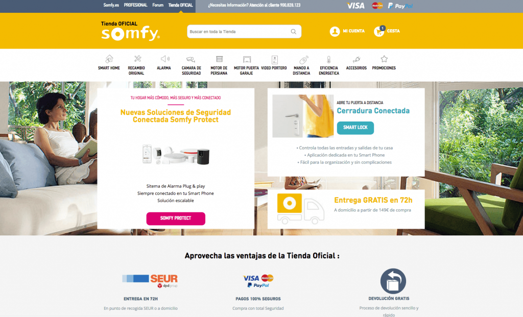 Sitio web de Somfy; muestra productos de seguridad y automatización. Textos destacados: "Nuevas Soluciones de Seguridad", "Entrega GRATIS en 72h". Entorno moderno y luminoso.