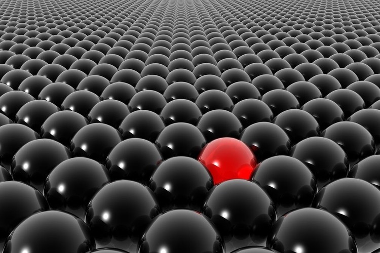 Esfera roja destacada entre muchas negras, simbolizando singularidad y diferenciaci&oacute;n en un contexto de uniformidad. Ideal para marketing diferencial.