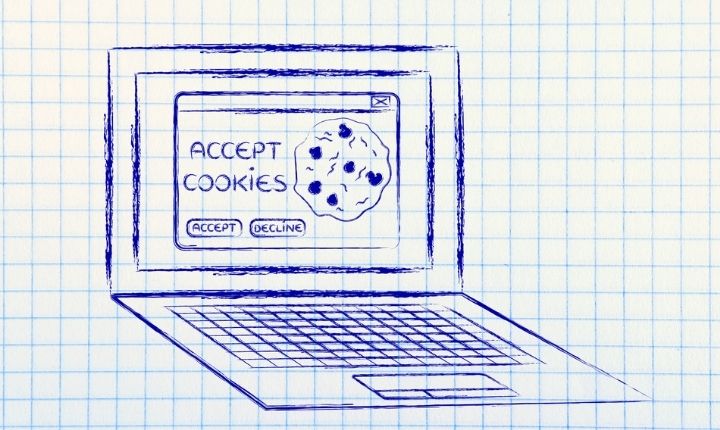 Portátil muestra ventana emergente con texto "ACCEPT COOKIES", botones "ACCEPT" y "DECLINE", y dibujo de una galleta, sobre fondo cuadriculado.