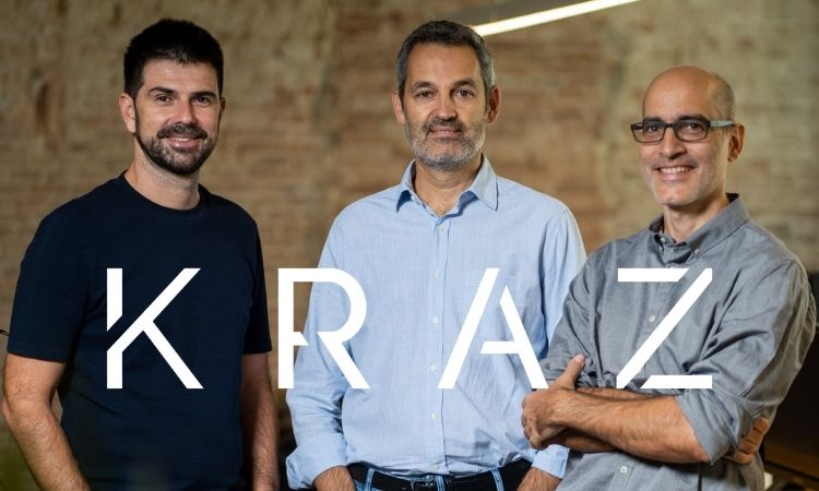 Tres hombres sonrientes están de pie, vestidos casualmente, sobre un fondo de ladrillo. Texto: "KRAZ". Ambiente profesional y moderno.