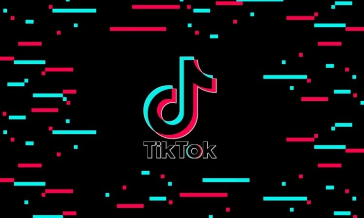 Logotipo de TikTok centrado, sin movimiento, rodeado de líneas rojas y turquesas sobre fondo negro, evocando estética moderna y digital.