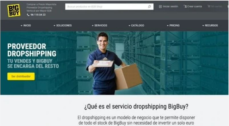 Hombre sonriente sostiene caja en almac&eacute;n, promocionando servicios de dropshipping de BigBuy. Texto: "Proveedor Dropshipping. T&uacute; vendes y BigBuy se encarga del resto."