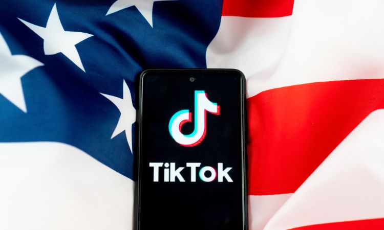 Imagen de un móvil con el logo de tiktok sobre la bandera de Estados Unidos, donde el estado de Montana ha prohibido TikTok