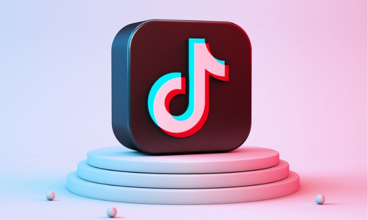 Sobre un pedestal iluminado con luces azules y rosas aparece en 3D el símbolo de TikTok, red social que acaba de anunciar su nueva biblioteca de contenido comercial