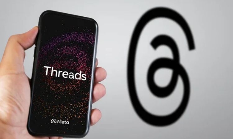 Imagen que muestra una persona sosteniendo un celular con el logotipo de Threads