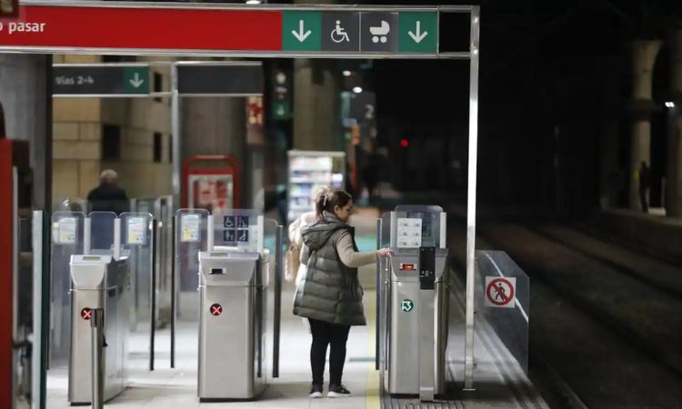 Una persona pasando su ticket por un torno en la estación de Renfe