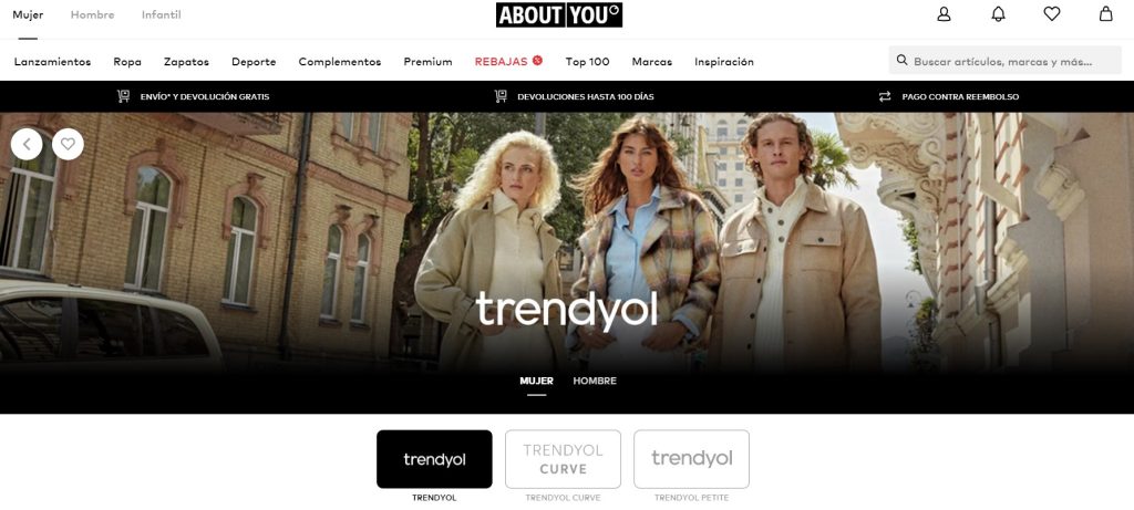 Personas posan con ropa de moda en una calle urbana, al lado de un edificio de ladrillo. Sobre la imagen, texto: "trendyol". Palabras clave: tendencia, estilo.